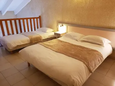 a hotel room with two beds in a room at Hotel & Restaurant le Saint Jean in Cargèse