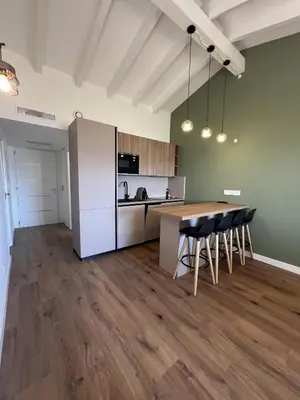 a kitchen with a table and chairs in a room at Les Mini-Villas de Santa Giulia in Porto-Vecchio