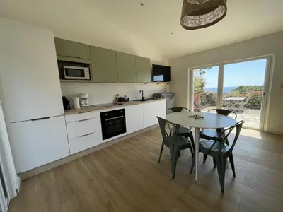 a kitchen and dining room with a table and chairs at Les Mini-Villas de Santa Giulia in Porto-Vecchio