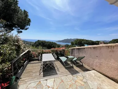 a wooden deck with two chairs and a table at Les Mini-Villas de Santa Giulia in Porto-Vecchio