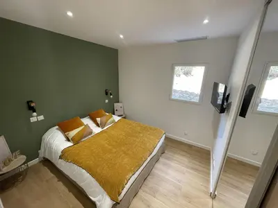 a bedroom with a bed with a yellow blanket at Les Mini-Villas de Santa Giulia in Porto-Vecchio