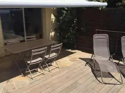 a table and four chairs on a deck with a table and a table and chairs at Les Mini-Villas de Santa Giulia in Porto-Vecchio