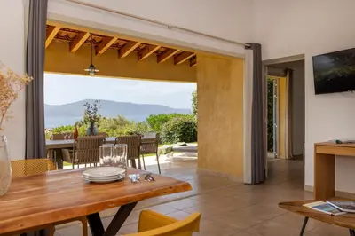 a dining room with a table and a view of the ocean at Résidence La Plage in Propriano