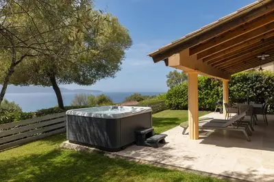 a hot tub sitting on a patio under a pavilion at Résidence La Plage in Propriano