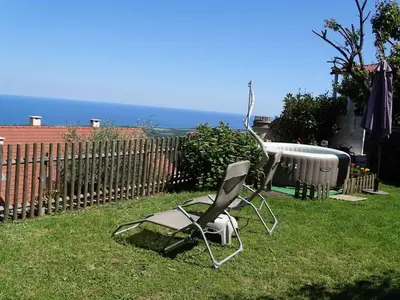 a chair sitting in the grass in a yard at CASA PENTONE in Cervione