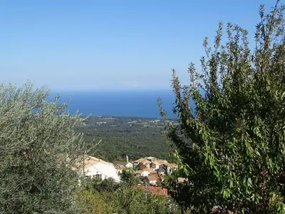 a view of a town from behind some trees at CASA PENTONE in Cervione