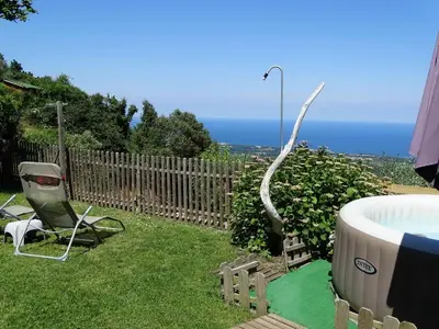 a garden with a chair and a hot tub at CASA PENTONE in Cervione