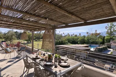 a patio with a table and chairs on a deck at Résidence I Levri in Porto-Vecchio