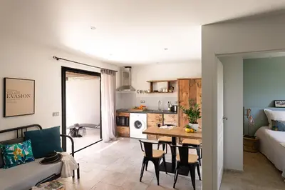 a kitchen and living room with a table and chairs at Résidence I Levri in Porto-Vecchio