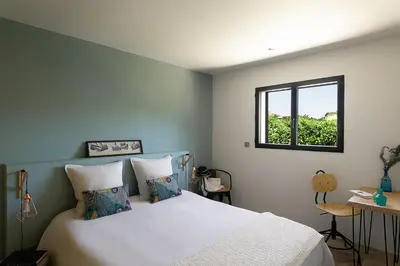 a bedroom with a white bed with a window at Résidence I Levri in Porto-Vecchio