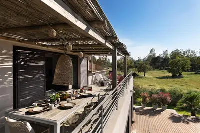 a deck with a long table on a house at Résidence I Levri in Porto-Vecchio