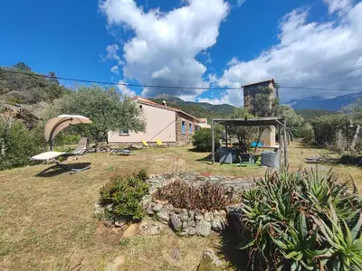 a garden with a house in the background at Au pont de Tuarelli, Ludique, Galeria, Corse in Manso
