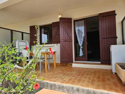 a patio with a table and chairs in a house at CARDELLINI 23 in Sari Solenzara