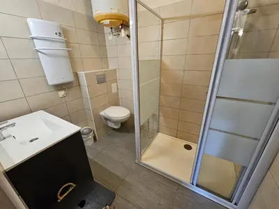 a bathroom with a shower and a toilet and a sink at CARDELLINI 23 in Sari Solenzara