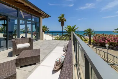 a balcony with benches and the ocean in the background at Hotel & Restaurant San Pellegrino in Folelli