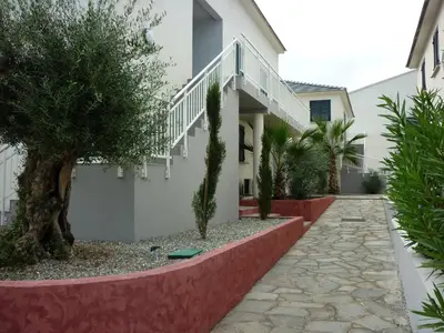 a house with a walkway and trees in front of it at Residence Marea Resort in Santa-Lucia-di-Moriani