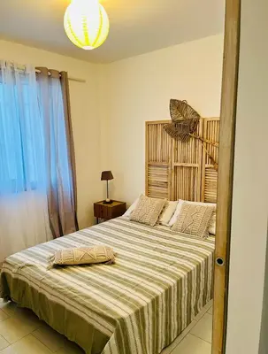 a bedroom with a large bed with a striped blanket at Résidence Valledoro in Valle-di-Campoloro