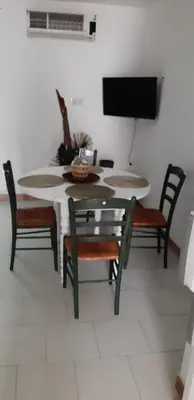 a dining room with a table and chairs and a tv at Résidence Valledoro in Valle-di-Campoloro