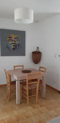 a dining room table and chairs with a painting on the wall at Résidence Valledoro in Valle-di-Campoloro