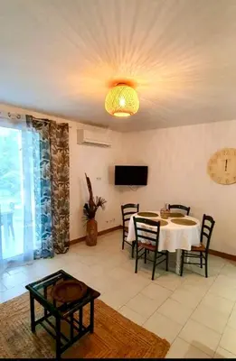 a dining room with a table and chairs and a chandelier at Résidence Valledoro in Valle-di-Campoloro