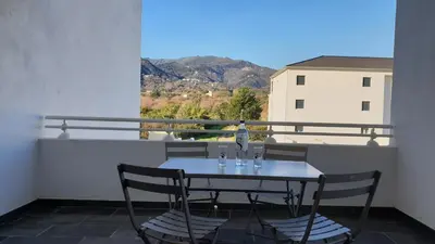 a table and chairs on a balcony with a view at OSARI - MORIANI plage in Moriani Plage