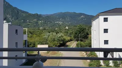 a balcony with a view of a road and mountains at OSARI - MORIANI plage in Moriani Plage