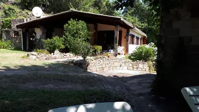a house with a stone wall in front of it at DISCRET, APAISANT, CALME entre MER et MONTAGNE, THERMALISME in Isolaccio-di-Fiumorbo