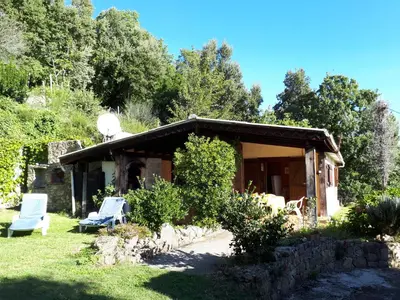a house with two chairs in the yard at DISCRET, APAISANT, CALME entre MER et MONTAGNE, THERMALISME in Isolaccio-di-Fiumorbo