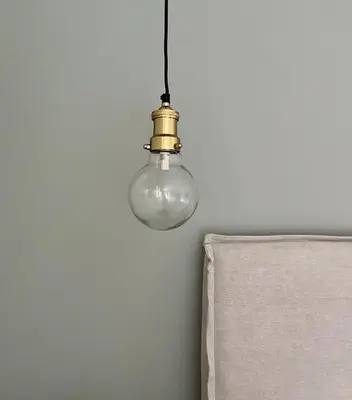 a light bulb hanging from a wall next to a chair at Maison Le Citronnier avec piscine - Domaine E Case Di Cuttoli in Cuttoli-Corticchiato