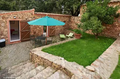 a garden with a table and an umbrella at Maison Le Citronnier avec piscine - Domaine E Case Di Cuttoli in Cuttoli-Corticchiato