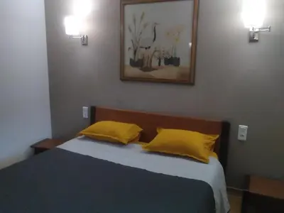 a bedroom with a bed with two yellow pillows at Maison L'Oranger avec piscine - Domaine E Case di Cuttoli in Cuttoli-Corticchiato