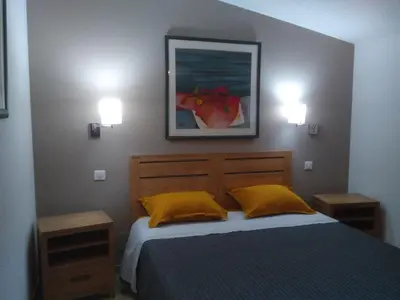 a bedroom with a bed and two lights on the wall at Maison L'Oranger avec piscine - Domaine E Case di Cuttoli in Cuttoli-Corticchiato