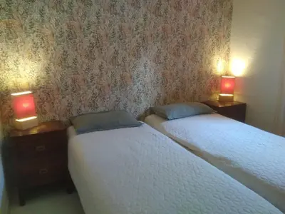 two beds in a room with two lamps on the wall at Maison L'Olivier avec piscine in Cuttoli-Corticchiato