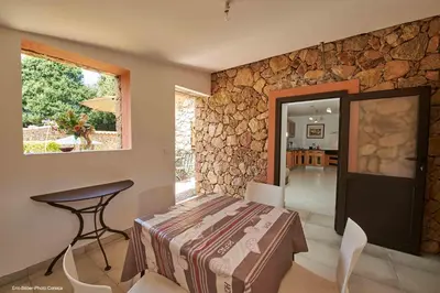 a room with a bed and a table and a window at Maison L'Olivier avec piscine in Cuttoli-Corticchiato