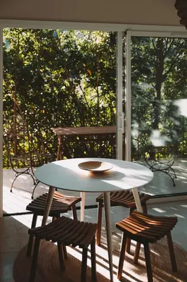 a white table and chairs on a porch with a window at L'Aiglon in Serriera