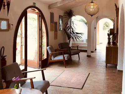 a living room with an archway and chairs and tables at Hôtel du Golfe in Sartène