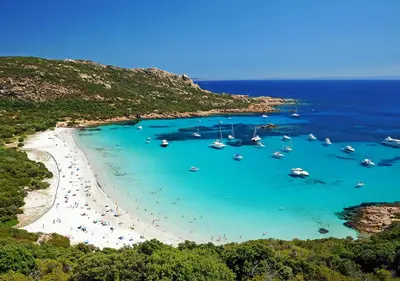 a group of boats in the water on a beach at Hôtel du Golfe in Sartène