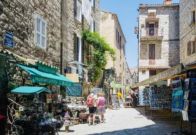 a group of people walking down a street at Hôtel du Golfe in Sartène