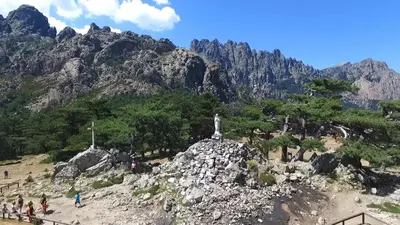 a mountain with a statue on top of a rock at Hôtel du Golfe in Sartène