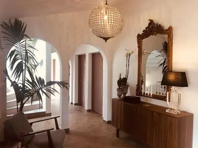 a living room with a mirror and a chair at Hôtel du Golfe in Sartène