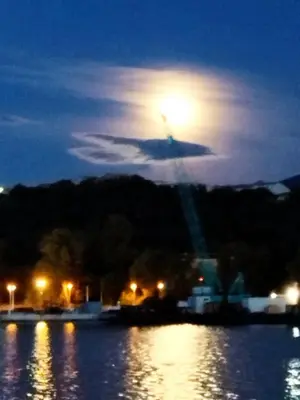a full moon rising over a body of water at night at seuls à bord dans le golfe hebergement atypique in Porto-Vecchio