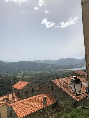 a view of roofs of houses and a street light at Location atypique village olmeto in Olmeto