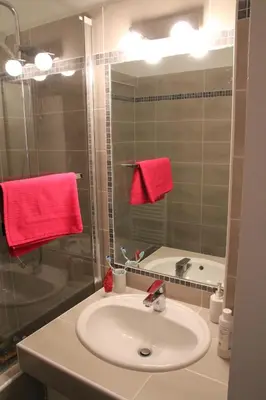 a bathroom with a sink and a shower with red towels at Appartement Sampiero in Corte