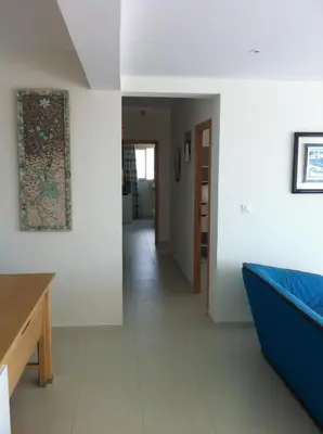a living room with a blue couch and a hallway at Vizzavona Piscine in Ajaccio