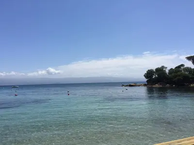 a beach with people swimming in the water at Vizzavona Piscine in Ajaccio