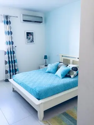 a bedroom with a bed with blue sheets and blue pillows at Vizzavona Piscine in Ajaccio