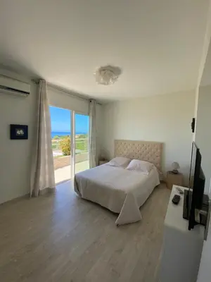 a bedroom with a bed and a large window at VIzzavona piscine et jacuzzi in Ajaccio