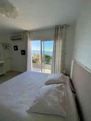 a bedroom with a bed with a view of the ocean at VIzzavona piscine et jacuzzi in Ajaccio