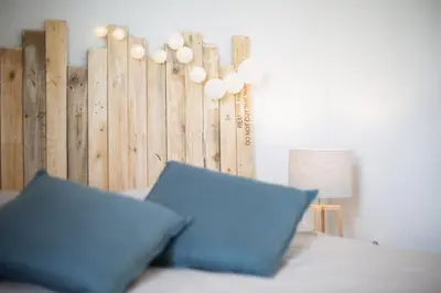 a bed with a blue pillow in a room at Evasion Marine - T2 Vue mer - Terrasse - Plage à pied in Ajaccio