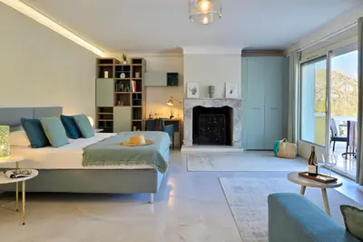 a bedroom with a large bed and a fireplace at Hotel Bartaccia in Propriano